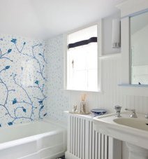 Белое панно с синим рисунком разбавляет стерильно белый цвет ванной